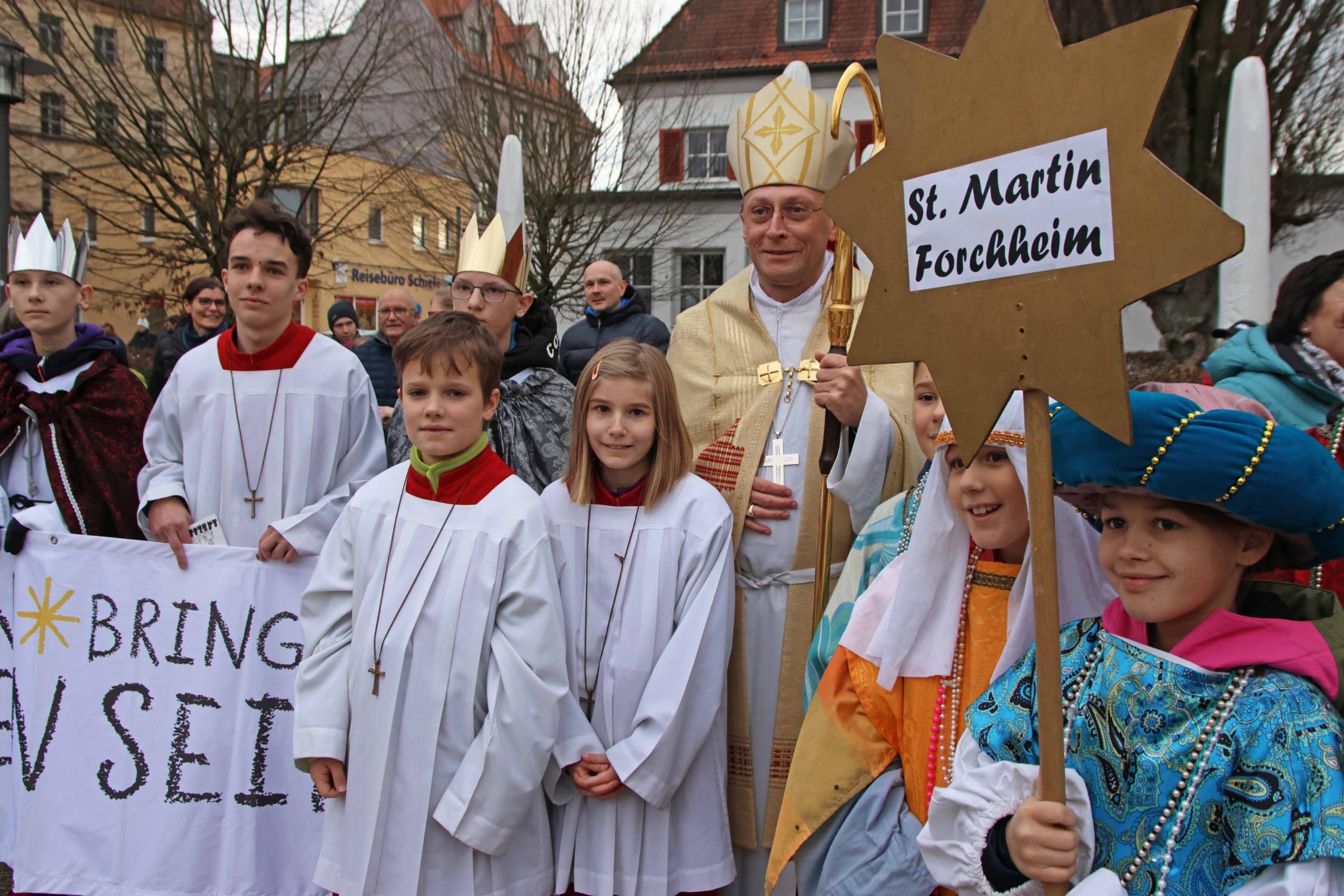 Eine Sternsinger-Gruppe mit Weihbischof Herwig Gössl auf dem Marktplatz in Forchheim.